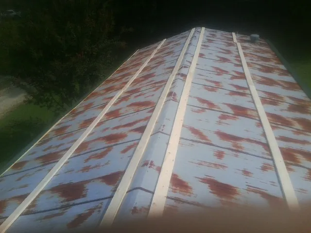 Rusted metal roof panels with new wood purlins before replacement — Storm Damage Roof Repair in Levels by Roofing Brothers