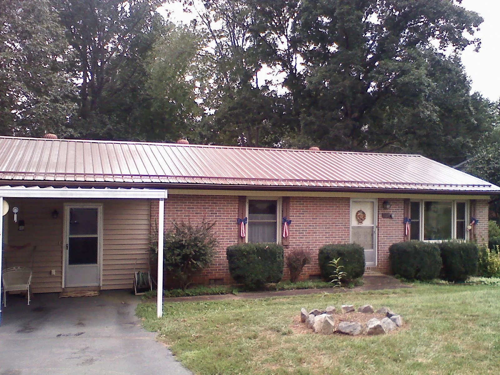 Bronze metal roof and carport on a brick ranch home — Roof Repair work by our crew in Levels